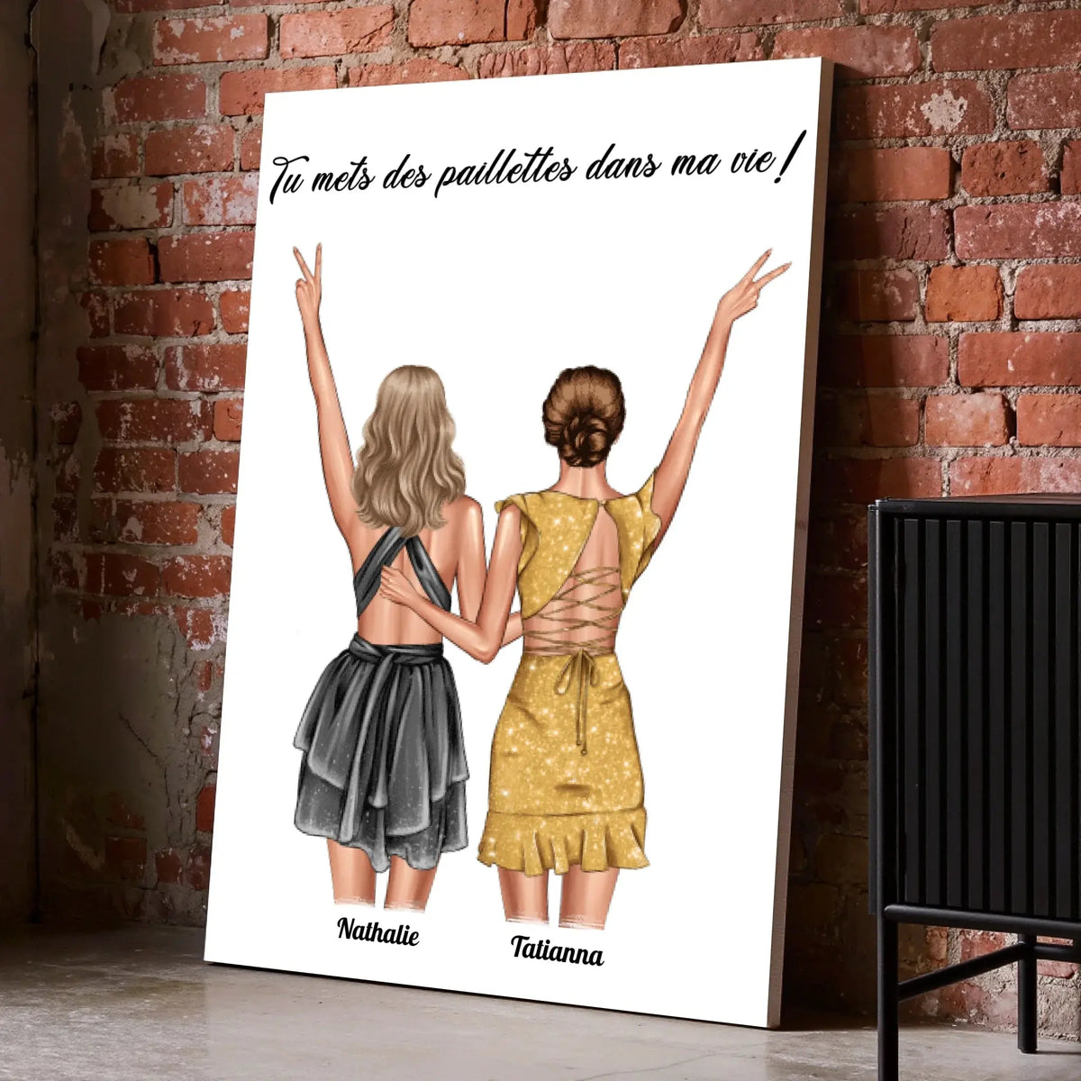 Affiche personnalisée couple de femmes posée au sol sur mur de briques rouges, entourée de cadres