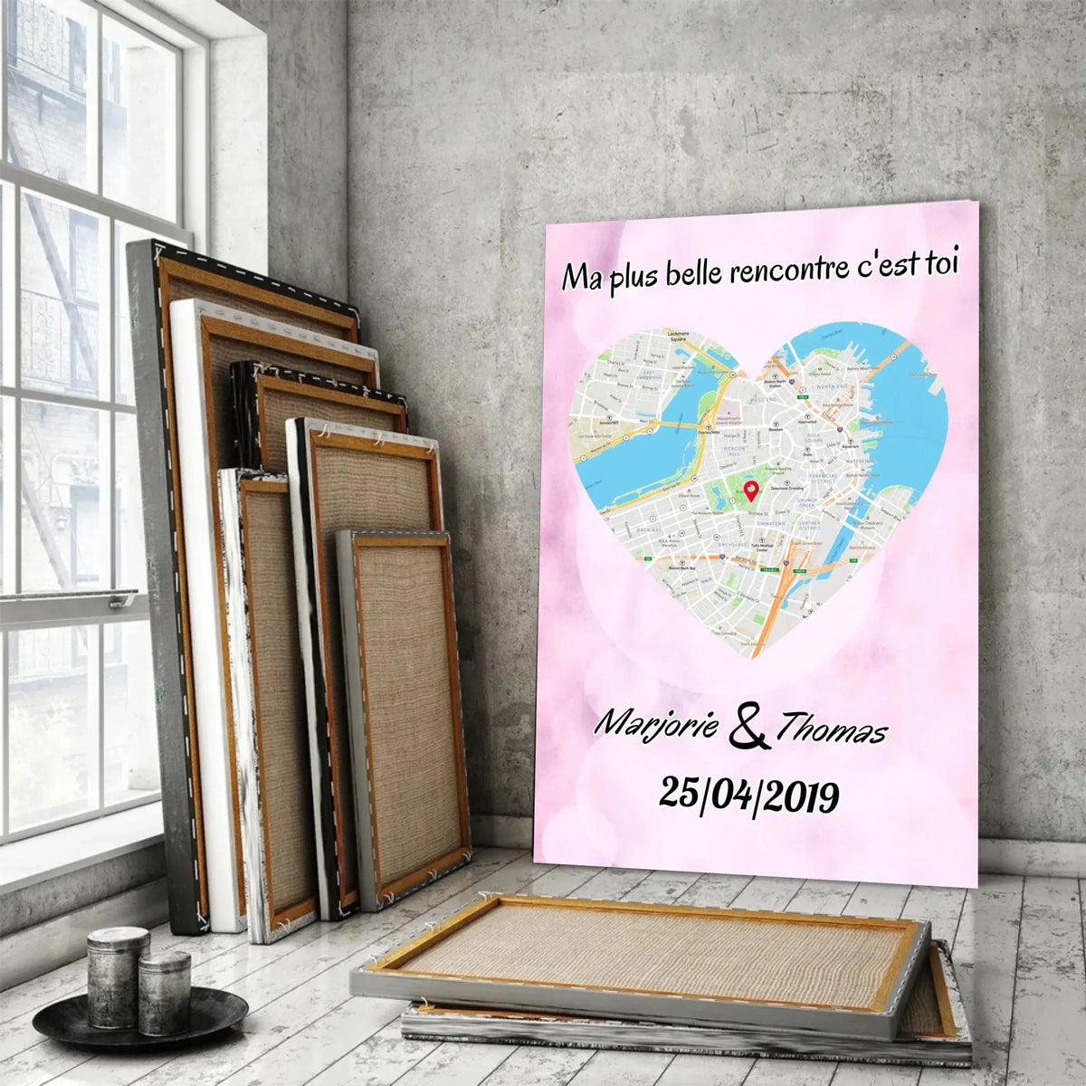Affiche personnalisée maps style cœur dans un loft, près d'une fenêtre, cadres en bois empilés