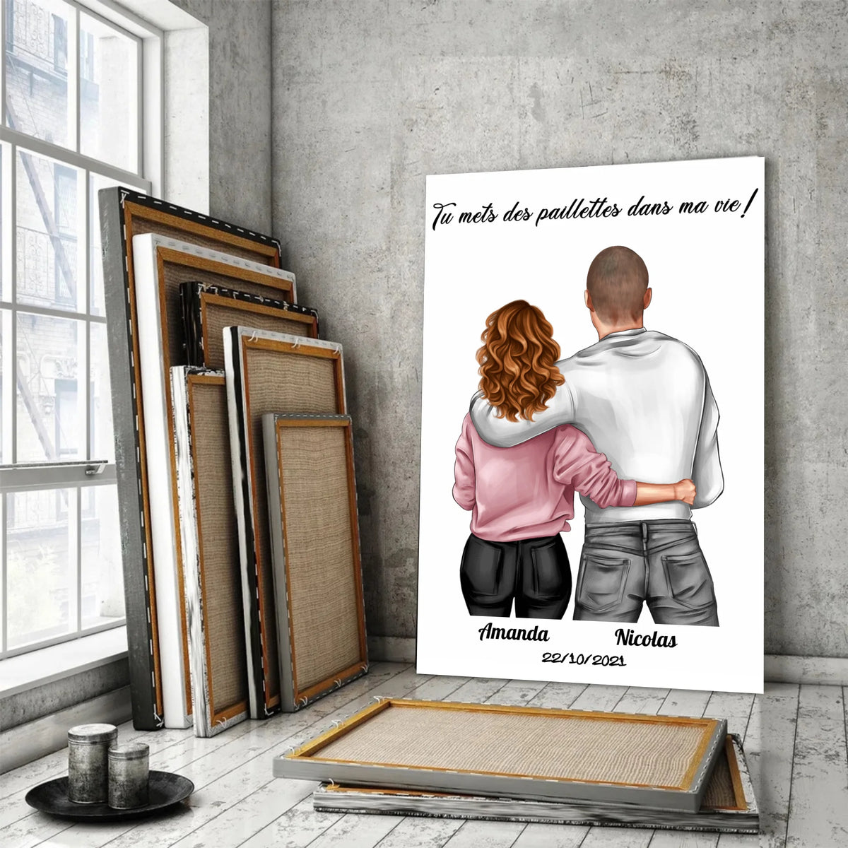 Tableau couple personnalisé homme et femme sur toile, posé devant des cadres empilés près d'une fenêtre