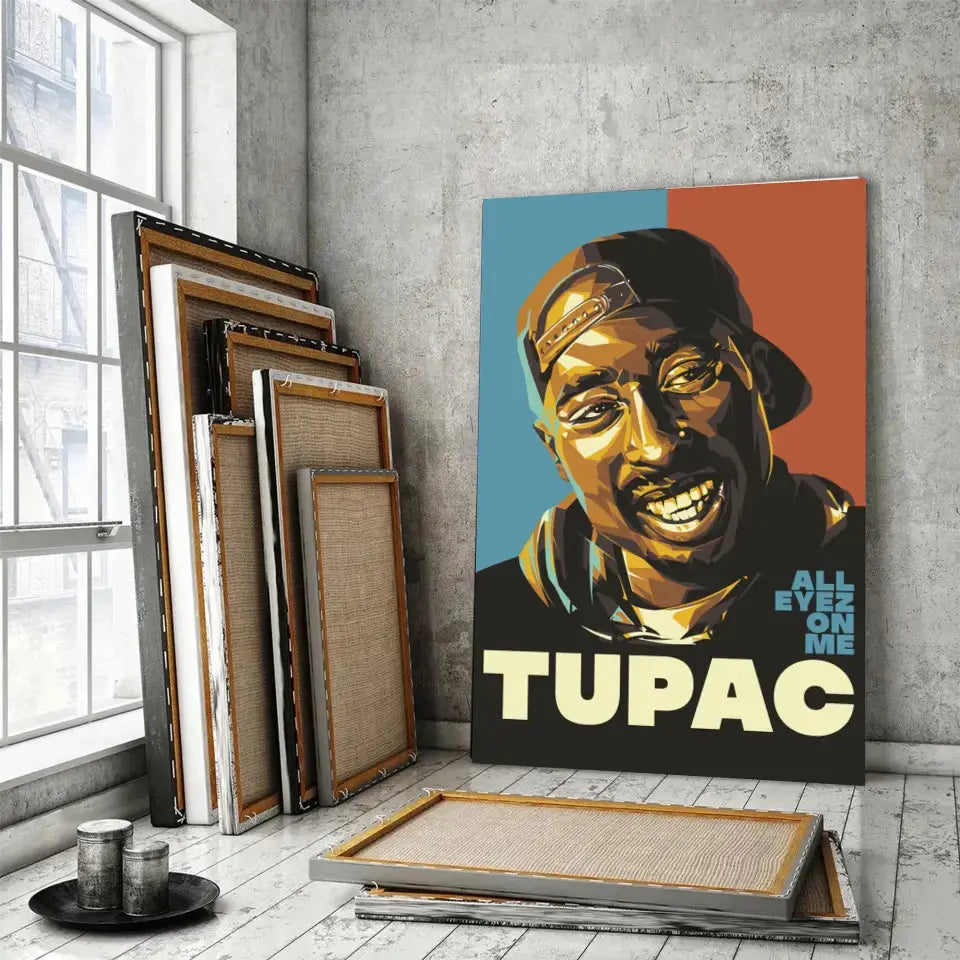 Tableau Décoratif 2Pac All Eyez On Me sur toile, posé devant des cadres empilés près d'une fenêtre