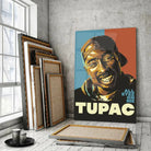 Tableau Décoratif 2Pac All Eyez On Me en verre acrylique, posé devant des cadres empilés