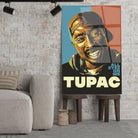 Tableau Décoratif 2Pac All Eyez On Me en verre acrylique, posé sur des tabourets devant un mur de briques