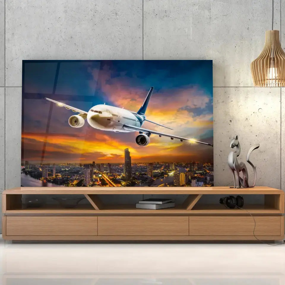Tableau Décoratif avion de nuit en verre acrylique, posé sur un meuble TV en bois devant un mur en béton