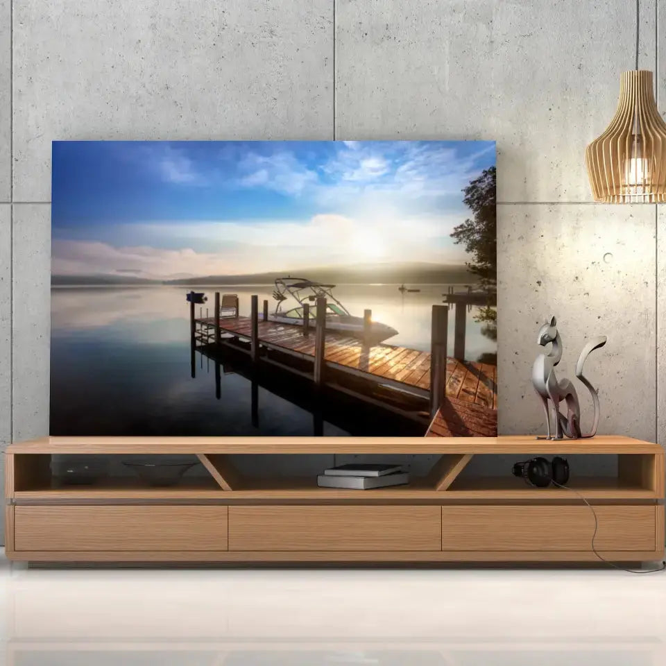 Tableau Décoratif Bateau Lac et Ponton sur toile, posée sur un meuble TV en bois devant un mur en béton