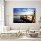 Tableau Décoratif Bateau Lac et Ponton sur toile, accrochée dans un salon lumineux au-dessus d'un canapé beige