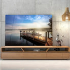 Tableau Décoratif Bateau Lac et Ponton en verre acrylique, posé sur un meuble TV en bois devant un mur en béton