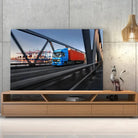 Tableau Décoratif camion remorque sur toile, posée sur un meuble TV en bois devant un mur en béton