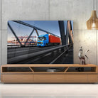 Tableau Décoratif camion remorque en verre acrylique, posé sur un meuble TV en bois devant un mur en béton