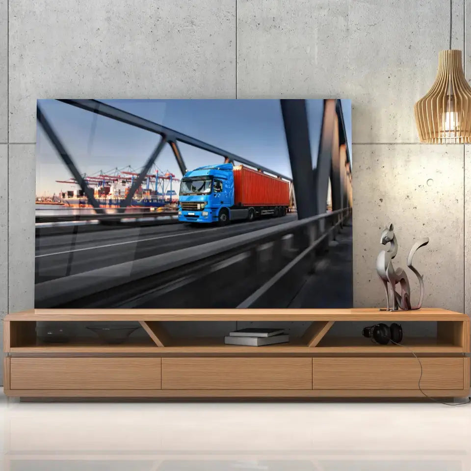 Tableau Décoratif camion remorque en verre acrylique, posé sur un meuble TV en bois devant un mur en béton