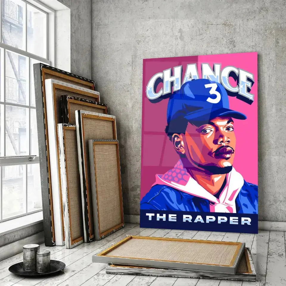 Tableau Décoratif Chance The Rapper en verre acrylique, posé devant des cadres empilés