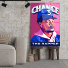 Tableau Décoratif Chance The Rapper en verre acrylique, posé sur des tabourets devant un mur de briques
