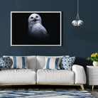 Tableau Décoratif Chouette Blanche en affiche encadrée dans un salon bleu nuit au-dessus d'un canapé blanc