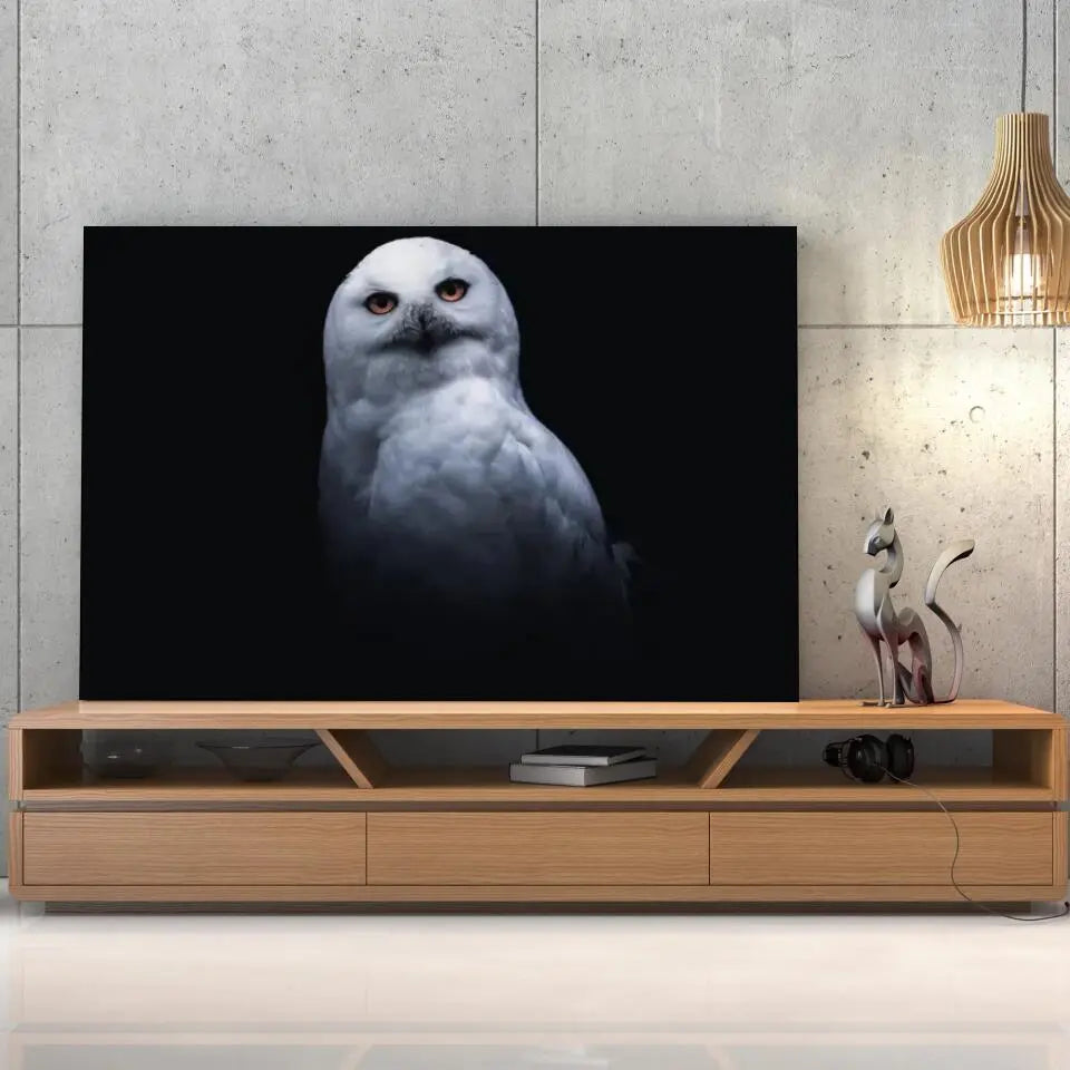 Tableau Décoratif Chouette Blanche sur toile, posée sur un meuble TV en bois devant un mur en béton