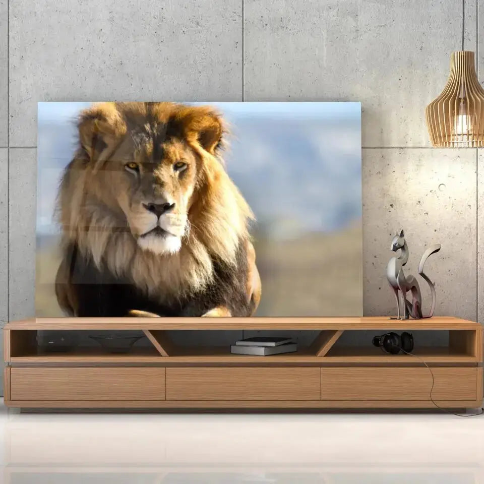 Tableau Décoratif Lion d'Afrique en verre acrylique, posé sur un meuble TV en bois devant un mur en béton