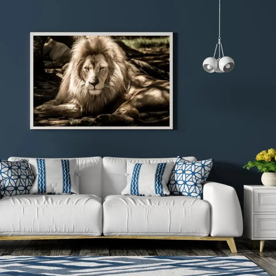 Tableau Décoratif Lion de l'Atlas en affiche encadrée dans un salon bleu nuit au-dessus d'un canapé blanc
