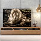 Tableau Décoratif Lion de l'Atlas en verre acrylique, posé sur un meuble TV en bois devant un mur en béton