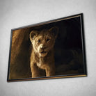Tableau Décoratif Lion de la Grotte en affiche dans un cadre noir, vue inclinée sur un mur gris