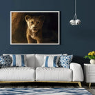 Tableau Décoratif Lion de la Grotte en affiche encadrée dans un salon bleu nuit au-dessus d'un canapé blanc