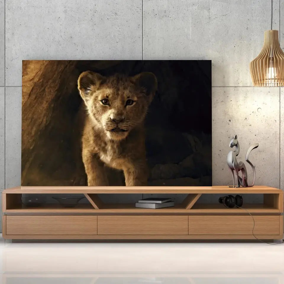 Tableau Décoratif Lion de la Grotte sur toile, posée sur un meuble TV en bois devant un mur en béton