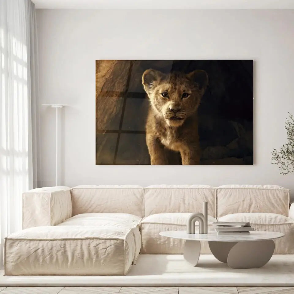 Tableau Décoratif Lion de la Grotte en verre acrylique, accroché dans un salon lumineux au-dessus d'un canapé beige