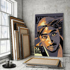 Tableau Décoratif Tupac Shakur 2Pac sur toile, posé devant des cadres empilés près d'une fenêtre