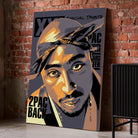 Tableau Décoratif Tupac Shakur 2Pac sur toile, posé au sol contre un mur de briques rouges