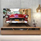 Tableau Décoratif Voiture Chevrolet Cuba en verre acrylique, posé sur un meuble TV en bois devant un mur en béton