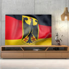 Tableau Drapeau Allemagne sur toile, posée sur un meuble TV en bois devant un mur en béton