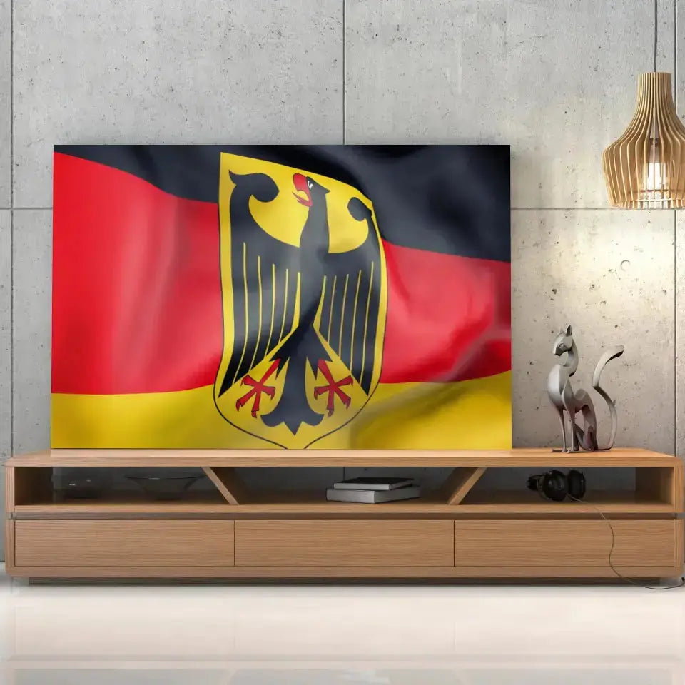 Tableau Drapeau Allemagne sur toile, posée sur un meuble TV en bois devant un mur en béton