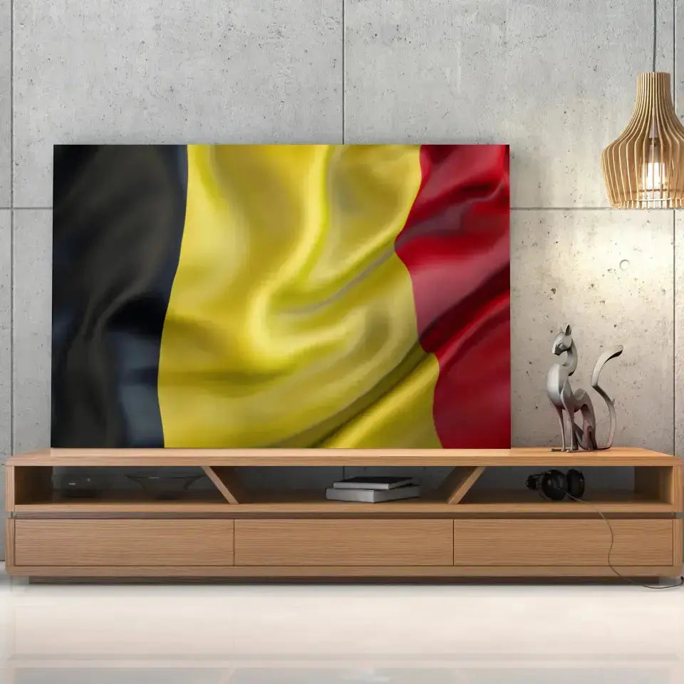 Tableau Drapeau Belgique sur toile, posée sur un meuble TV en bois devant un mur en béton