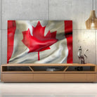Tableau Drapeau Canada en verre acrylique, posé sur un meuble TV en bois devant un mur en béton