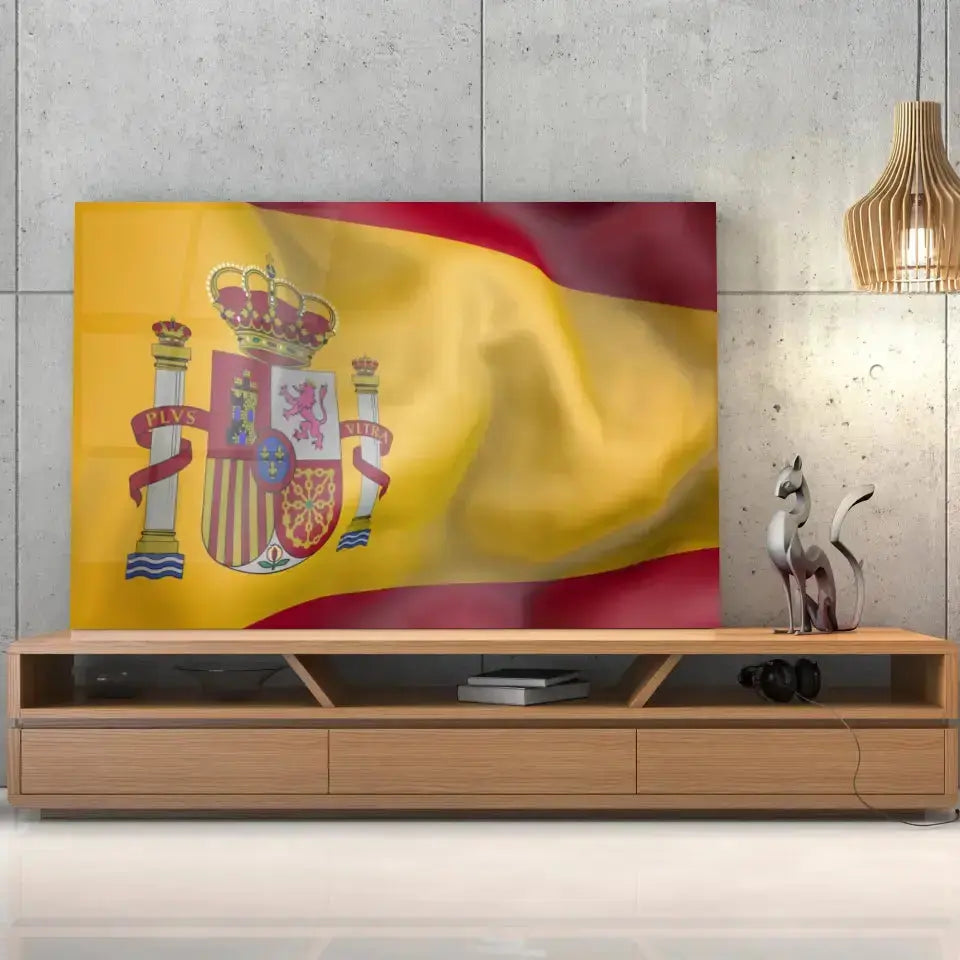 Tableau Drapeau Espagne en verre acrylique, posé sur un meuble TV en bois devant un mur en béton