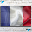 Tableau Drapeau France en verre acrylique, vue de face sur un mur de briques blanches
