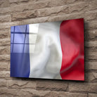 Tableau Drapeau France en verre acrylique, fixé sur un mur de pierre