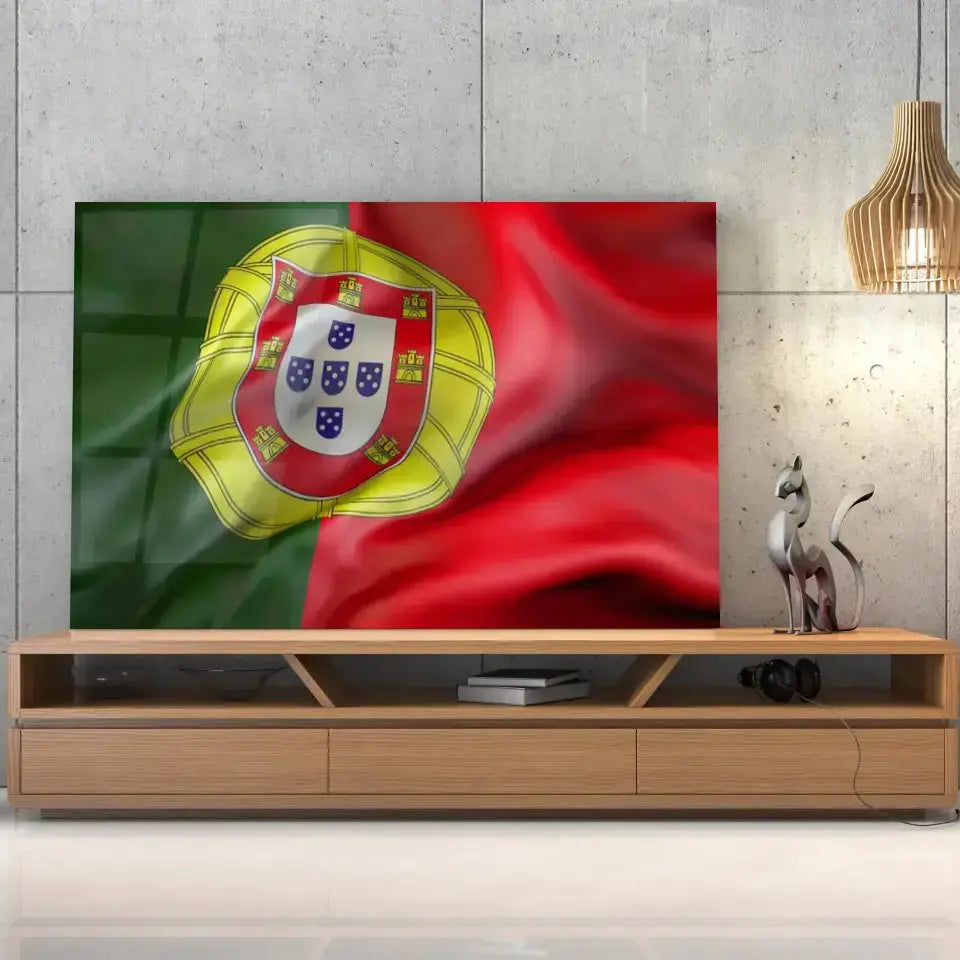 Tableau Drapeau Portugal en verre acrylique, posé sur un meuble TV en bois devant un mur en béton