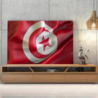 Tableau Drapeau Tunisie sur toile, posée sur un meuble TV en bois devant un mur en béton