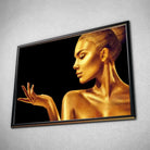 Tableau Femme glamour en or en affiche dans un cadre noir, vue inclinée sur un mur gris
