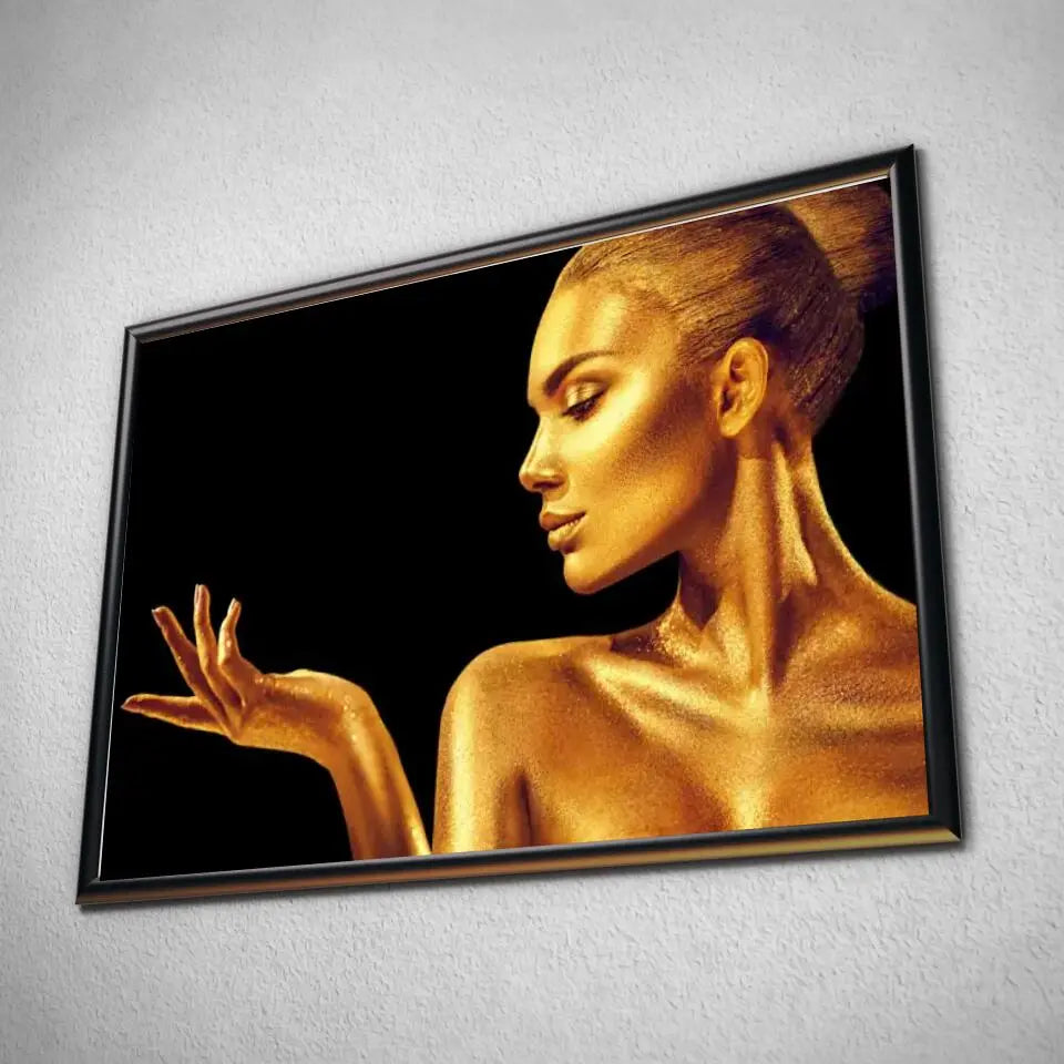 Tableau Femme glamour en or en affiche dans un cadre noir, vue inclinée sur un mur gris