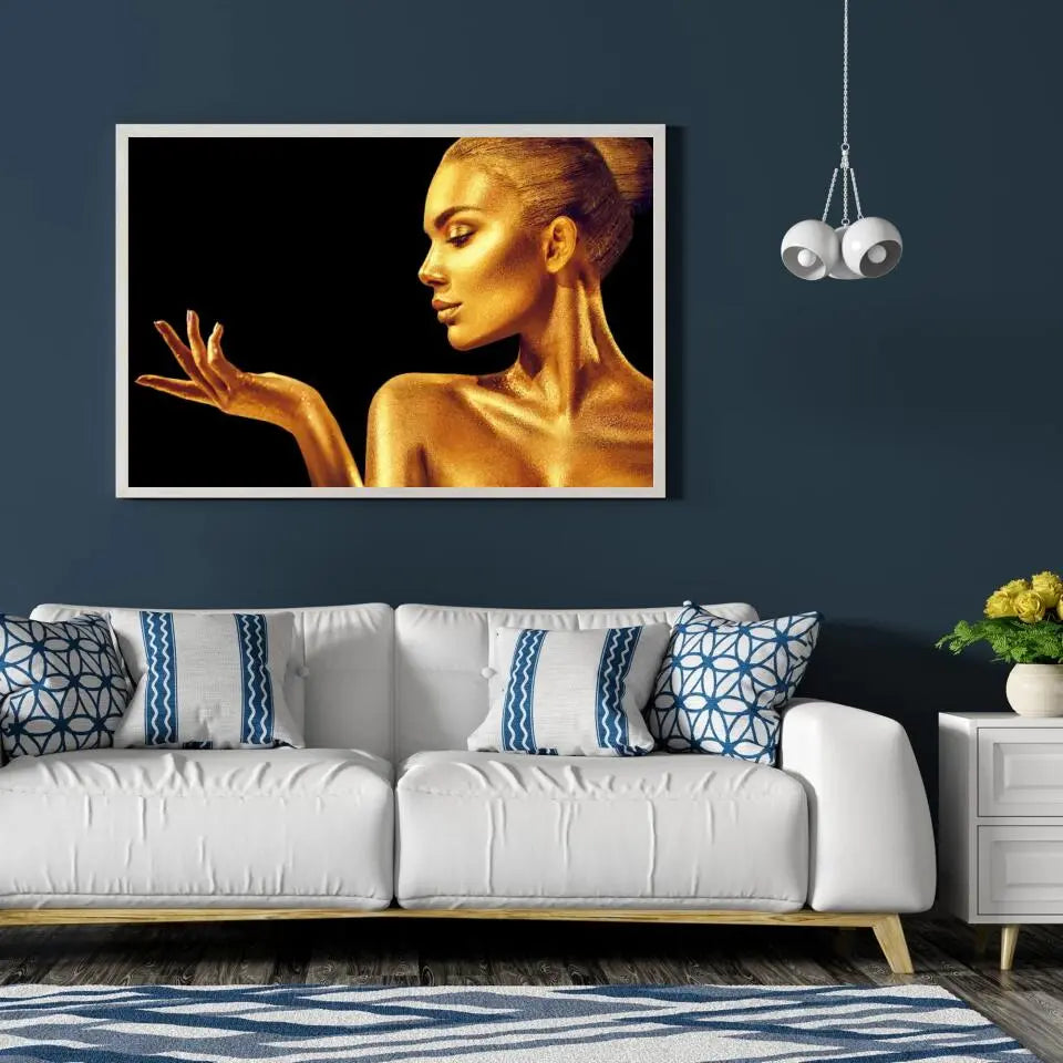 Tableau Femme glamour en or en affiche encadrée dans un salon bleu nuit au-dessus d'un canapé blanc