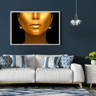 Tableau Femme maquillage en or en affiche encadrée dans un salon bleu nuit au-dessus d'un canapé blanc