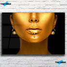 Tableau Femme maquillage en or en verre acrylique, vue de face sur un mur de briques blanches