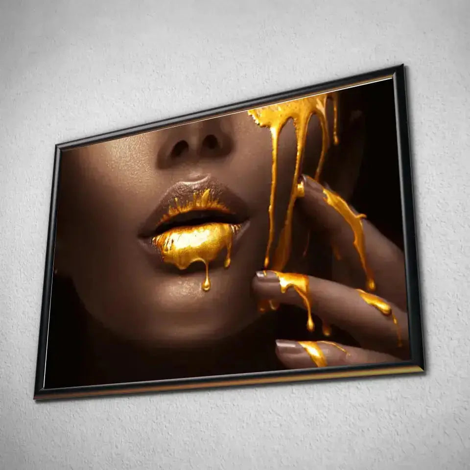 Tableau Lèvre et or liquide en affiche dans un cadre noir, vue inclinée sur un mur gris