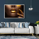Tableau Lèvre et or liquide en affiche encadrée dans un salon bleu nuit au-dessus d'un canapé blanc