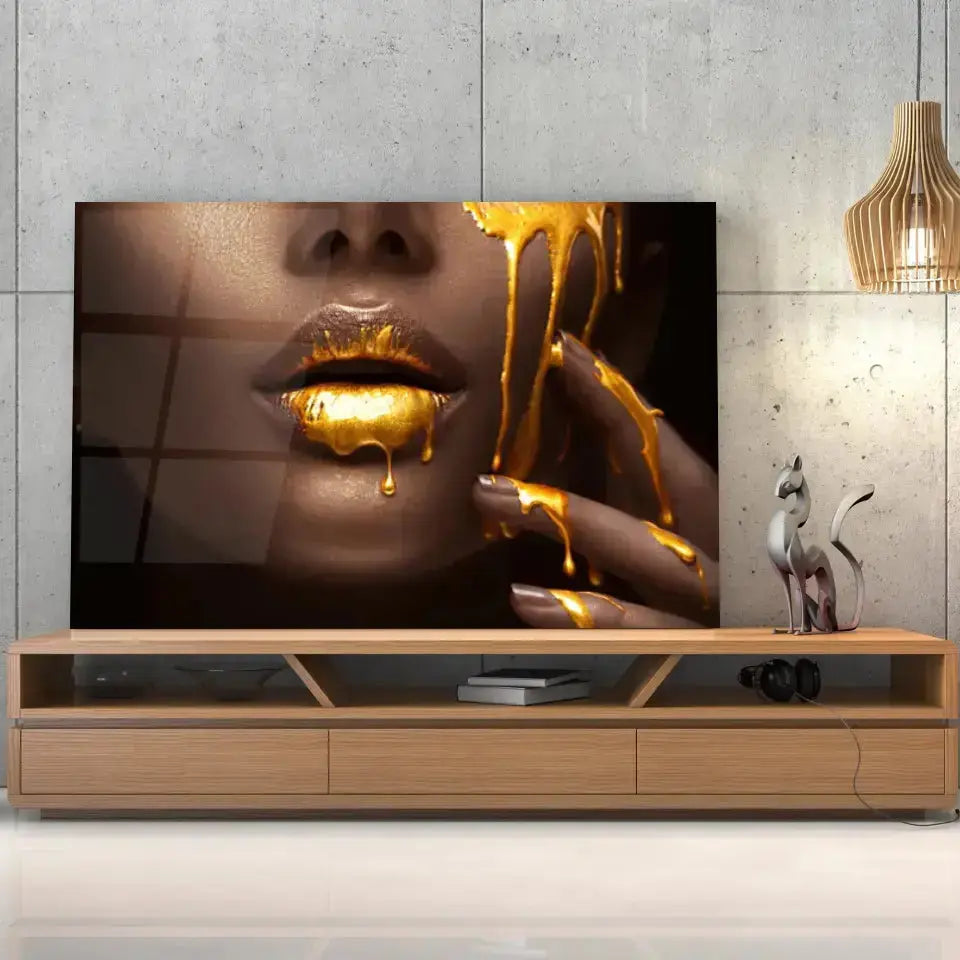 Tableau Lèvre et or liquide en verre acrylique, posé sur un meuble TV en bois devant un mur en béton