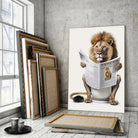 Tableau Lion aux toilettes sur toile, posé devant des cadres empilés près d'une fenêtre