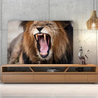Tableau Décoratif Lion Rugissant sur toile, posée sur un meuble TV en bois devant un mur en béton
