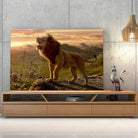 Tableau lion savane en verre acrylique, posé sur un meuble TV en bois devant un mur en béton