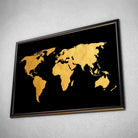 Tableau Décoratif Map Monde Fond Noir en affiche dans un cadre noir, vue inclinée sur un mur gris