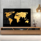 Tableau Décoratif Map Monde Fond Noir en verre acrylique, posé sur un meuble TV en bois devant un mur en béton
