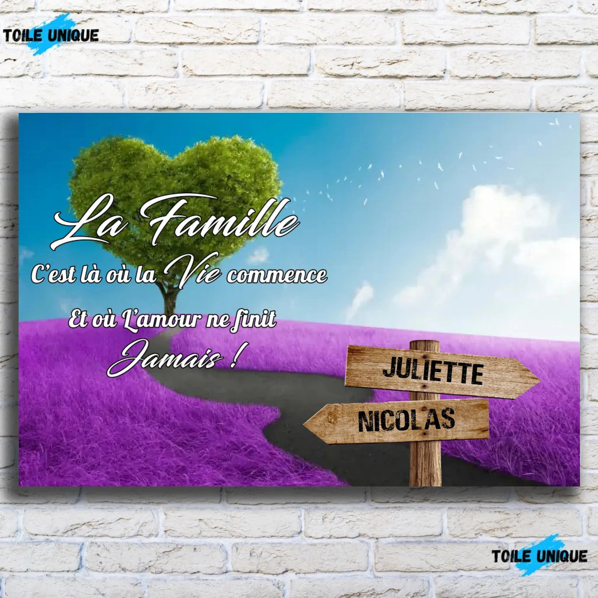 Tableau prénoms personnalisé arbre cœur et champ violet, vue de face sur mur de briques blanches